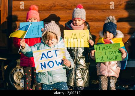 Giovani patrioti, attivisti per bambini. Piccole ragazze ucraine che chiedono di fermare la guerra sollevare banner con iscrizione fermare la guerra in Ucraina Foto Stock