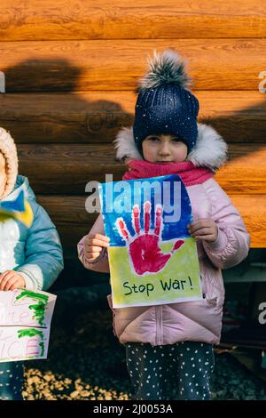 Giovani patrioti, attivisti per bambini. Piccole ragazze ucraine che chiedono di fermare la guerra sollevare banner con iscrizione fermare la guerra in Ucraina Foto Stock