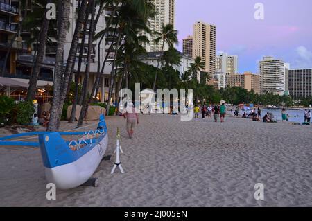 Gli straggler rimangono sulla spiaggia di Waikiki dopo che il sole è tramontato Foto Stock