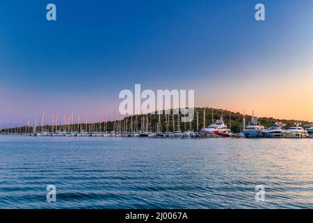 Tramonto sulla baia del mare nel villaggio di Rogoznica, una popolare destinazione turistica sulla costa dalmata del mare Adriatico in Croazia, Europa. Foto Stock