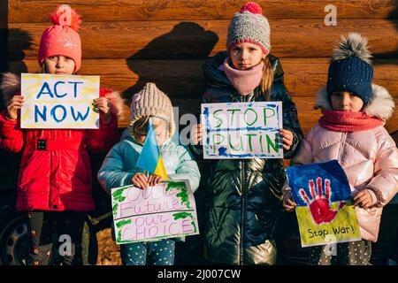 Giovani patrioti, attivisti per bambini. Piccole ragazze ucraine che chiedono di fermare la guerra sollevare banner con iscrizione fermare la guerra in Ucraina Foto Stock