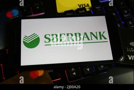 Viersen, Germania - Marzo 9. 2022: Visualizzazione sullo schermo del telefono cellulare sulla tastiera del computer con il logo della sberbank russa Foto Stock