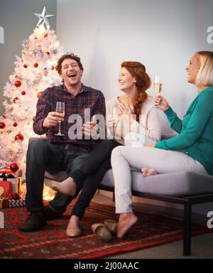 Feste amichevoli. Scatto di tre amici che si gustano un bicchiere di champagne a Natale. Foto Stock