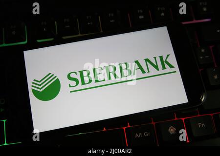 Viersen, Germania - Marzo 9. 2022: Visualizzazione sullo schermo del telefono cellulare sulla tastiera del computer con il logo della sberbank russa Foto Stock