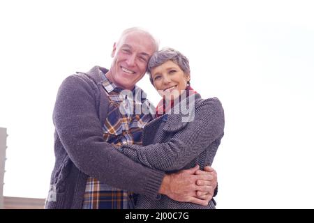 Il vero amore è senza tempo. Ritratto di una coppia anziana felice godendo di un momento pieno di affetto all'aperto. Foto Stock