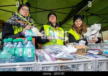 Przemysl, Polonia. 15th Mar 2022. I volontari polacchi attendono appena oltre il confine con l'Ucraina, al valico di frontiera di Medyka, per prendersi cura dei rifugiati dall'Ucraina. Agata (24, l) dalla Polonia occidentale, Daniel (27) da Varsavia e Asia (18) da Torun sono qui per l'organizzazione polacca ZHP e volontario per circa 12 ore al giorno al confine di Medyka, fornendo ai rifugiati le necessità di base. Molte persone in fuga dalla guerra dall'Ucraina arrivano in treno qui al confine in Polonia e poi continuano il loro viaggio in autobus o altro. Credit: Christoph Reichwein/dpa/Alamy Live News Foto Stock