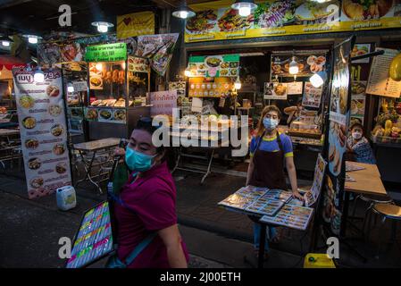 Bangkok, Tailandia. 15th Mar 2022. Un venditore attende i clienti di fronte ad un ristorante a Bangkok's Chinatown. Chinatown, conosciuta anche come Yaowarat, è la famosa destinazione per i turisti di notte, con molte bancarelle di cibo di strada e ristoranti cinesi. (Credit Image: © Peerapon Boonyakiat/SOPA Images via ZUMA Press Wire) Foto Stock