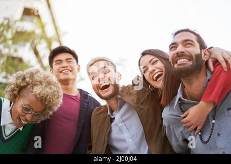 Tre coppie divertendosi piggybacking al tramonto Foto Stock