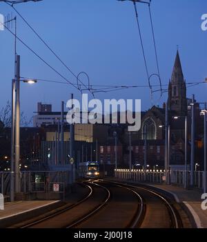 Nottingham Express Transit Bombardier Incentro tram 215 Brian Clough arrivo alla stazione ferroviaria di Nottingham al tramonto. Foto Stock