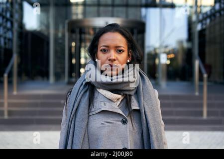 Giovane donna d'affari afroamericana seria che guarda la macchina fotografica. Signora potenziata in un luogo corporativo Foto Stock
