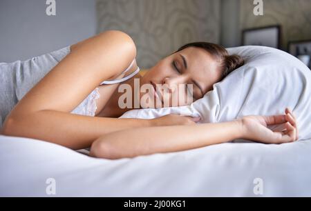 Sembra sempre un angelo al mattino. Scatto corto di una giovane donna sdraiata su un letto. Foto Stock