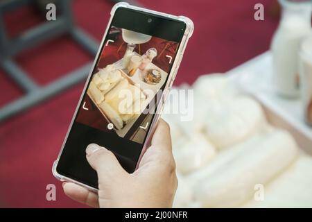 Primo piano di una mano che scatta foto di prodotti sul set di una televisione dal vivo Foto Stock