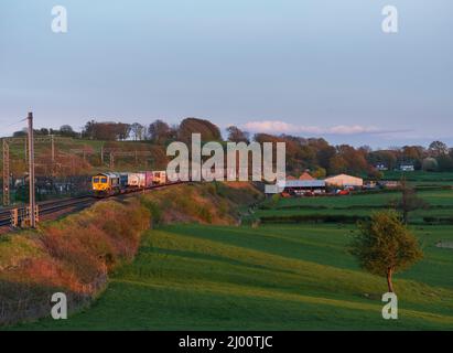 Locomotiva diesel Freightliner classe 66 sulla linea principale della costa occidentale del Lancashire con un treno container intermodale per il trasportatore stradale JG Russell Foto Stock