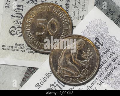 Vista dall'alto della parte anteriore e posteriore di una storica moneta da pfennig della Germania occidentale su sfondo cartaceo Foto Stock