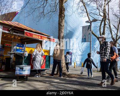 Seattle, WA USA - circa Marzo 2022: Persone in attesa in linea per acquistare cibo da un carrello hot dog nel centro di Seattle, vicino allo Space Needle e Chihuly Gard Foto Stock