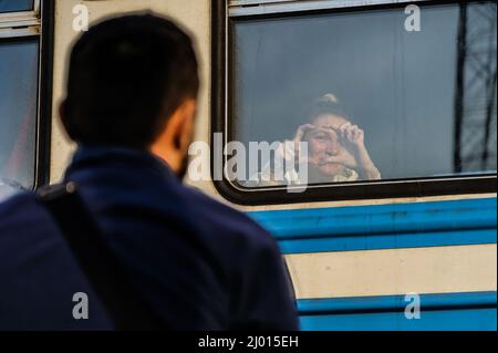 Lviv, Ucraina. 15th Mar 2022. Una donna fa segni di cuore su una finestra di treno per il suo uomo sulla strada per la Polonia alla stazione ferroviaria di Lviv in mezzo all'invasione russa in Ucraina. Lviv, la più grande città dell'Ucraina occidentale, è ora diventata un centro di transito per donne e bambini in fuga verso l'Europa, mentre gli uomini ritornano e si recano nell'Ucraina orientale per difendere il paese. (Foto di Mykola TYS/SOPA Images/Sipa USA) Credit: Sipa USA/Alamy Live News Foto Stock