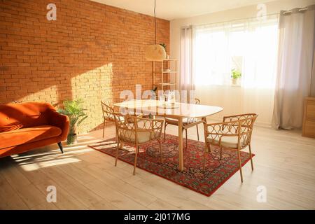 Interno di una moderna sala da pranzo con tavolo e tappeti vintage Foto Stock