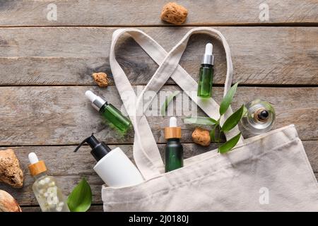 Shopping bag con cosmetici naturali su sfondo in legno Foto Stock