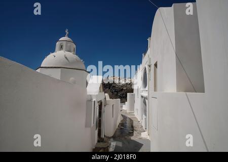 Un tipico vicolo che conduce ad una cappella ortodossa imbiancata sull'isola di Santorini in Grecia Foto Stock