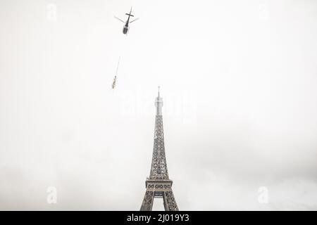 Parigi, Francia. 15th Mar 2022. Un elicottero solleva una nuova antenna sulla cima della Torre Eiffel a Parigi, in Francia, il 15 marzo 2022. La Torre Eiffel è cresciuta di sei metri il martedì dopo che una nuova antenna radio è stata installata sulla cima del monumento di Parigi, ad un'altezza di 330 metri. Credit: Florent Michel/Xinhua/Alamy Live News Foto Stock