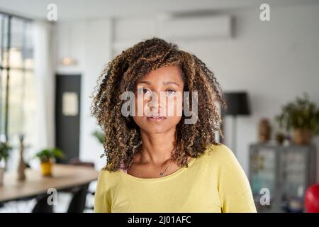 Ritratto di una bella giovane donna adulta serio espressione volto. Ragazza africana in casual guardando la macchina fotografica con. Gara mista sicura e rilassante Foto Stock