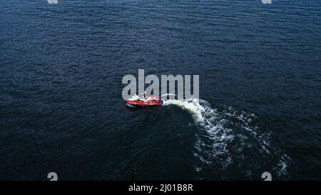 Scatto aereo di una barca rossa che deriva in mare Foto Stock