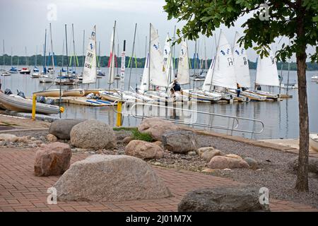 Scuola di vela barche a vela ormeggiate sul lago BDE Maka Ska (era il lago Calhoun) molo con una costa rocciosa. Minneapolis Minnesota, Stati Uniti Foto Stock