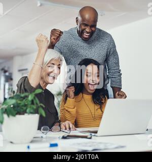 Finalmente stavano ottenendo da qualche parte. Scatto ritagliato di un gruppo di uomini d'affari allegri che guardano insieme uno schermo di un notebook mentre si entusiasma Foto Stock