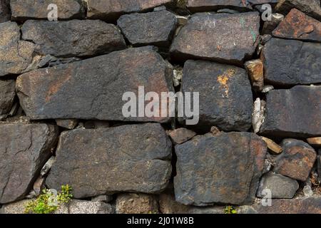 Primo piano del muro con pietre di varie dimensioni. Foto Stock