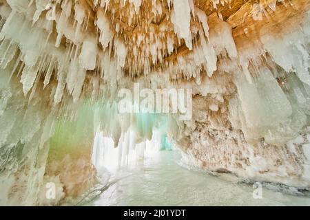 Caverna di ghiaccio sul lago ghiacciato con soffitto coperto di piccole ghiacciate Foto Stock