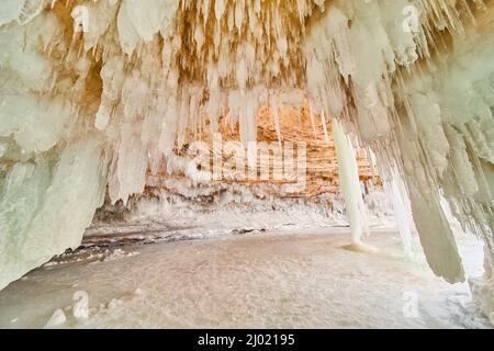 Ghiaccioli che coprono il soffitto di roccia ghiacciata caverna sul lago Foto Stock