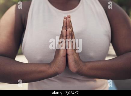 Namaste e ricordate di respirare. Shot di una donna meditating come parte della sua routine di allenamento. Foto Stock