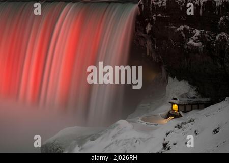 Le cascate Horseshoe si illuminarono in rosso e bianco in inverno, mostrando anche l'attrazione Journey Behind the Falls. Foto Stock