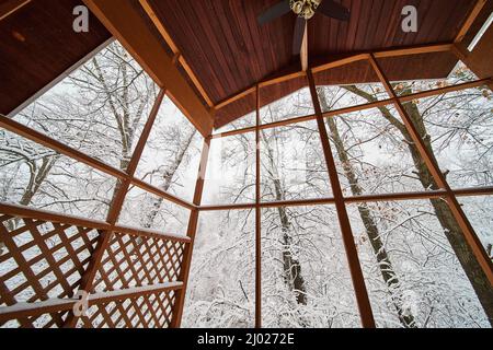 Vista all'interno del patio a tre stagioni in inverno con alberi coperti di neve Foto Stock