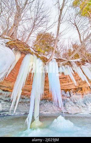 Costa delle scogliere dell'isola in inverno sul lago coperto di ghiaccioli blu giganti Foto Stock