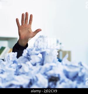 Potrei usare una mano qui. Shot di una mano degli impiegati che si accatastano fuori di lavoro di ufficio crollato in su. Foto Stock
