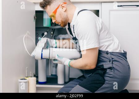 Filtro a cartuccia per cambio idraulico per acqua in cucina bianca. Sistema di filtrazione Concept. Foto Stock