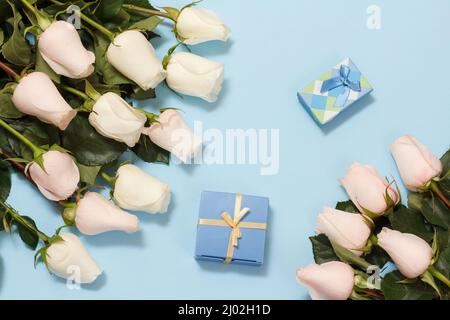 Scatole regalo con belle rose bianche sullo sfondo blu. Concetto di dare un regalo in vacanza. Vista dall'alto. Foto Stock