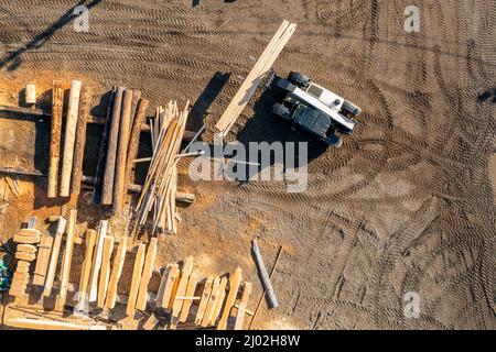 Il dumper con caricatore trasporta legname finito per la costruzione. Foto Stock