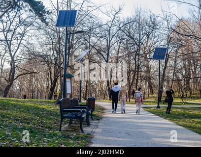 Giornata di sole sul lungomare nel parco cittadino di Kamenica, Novi Sad. Pannelli solari del sistema di energia alternativa sono stati installati sul lungomare in Foto Stock