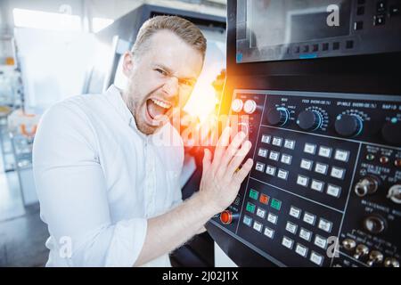 Impiegato del settore utilizzare il pulsante per l'intervento in caso di incidente sulla macchina sul pavimento della fabbrica. Foto Stock