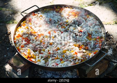 Preparazione della Paella nella classica padella grande Foto Stock