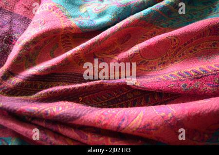 Tessuti insoliti e bellissimi, uno scialle da donna bellissimo, una sciarpa, una sciarpa fatta di materiali naturali. Tessuto delicato rosa, blu, rosso e viola. Foto Stock