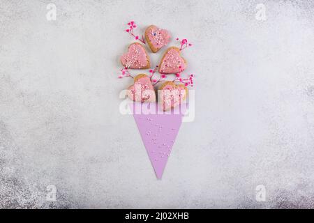 Biscotti rosa in forma di cuore in carta di mais come bouquet di fiori San Valentino giorno o madre giorno concetto fatto in casa. Foto Stock