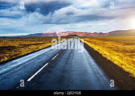 Strada vuota che porta alla zona geotermica di Hverir (Hverarond) vicino al lago Myvatn. Popolare attrazione turistica. Scena drammatica e pittoresca. Posizione Foto Stock