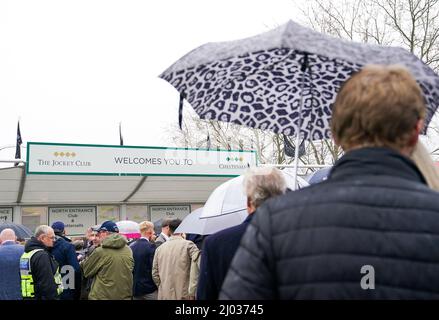 I Racegoers prendono rifugio sotto gli ombrelloni mentre si accodano davanti all'entrata il giorno due del festival di Cheltenham all'ippodromo di Cheltenham. Data foto: Mercoledì 16 marzo 2022. Foto Stock