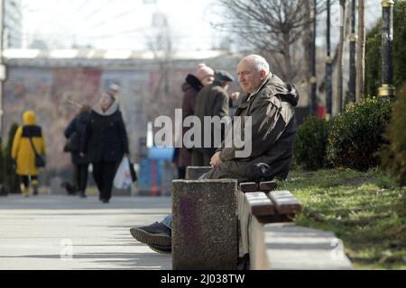 Non esclusiva: KYIV, UCRAINA - 15 MARZO 2022 - Un uomo siede sulla panchina nel centro di Kyiv, capitale dell'Ucraina Foto Stock