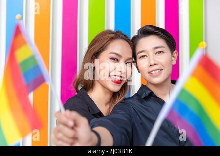 Asian LGBT coppia donne amico felice insieme sorridente con bandiera arcobaleno colorato per la campagna di destra transgender. Foto Stock