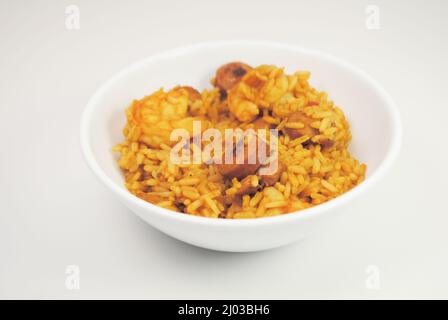 Gamberi e salsiccia Jambalaya servito in una ciotola bianca isolato su uno sfondo bianco Foto Stock