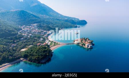 Vista dal drone volante. Vista panoramica dell'isola di Sveti Stefan in una splendida giornata estiva, Montenegro. Foto Stock